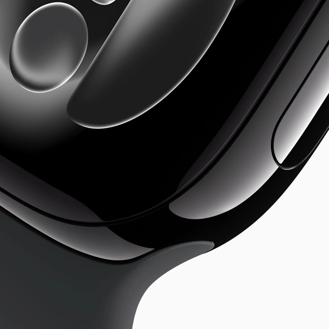 Primer plano macro del Apple Watch Jet Black, destacando su acabado negro brillante, el cristal curvo de la pantalla y la integración fluida de la correa.