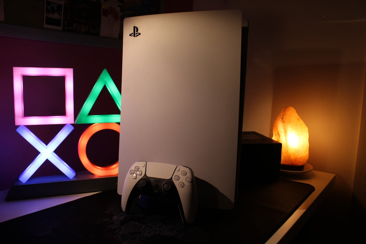 a video game console next to a neon sign