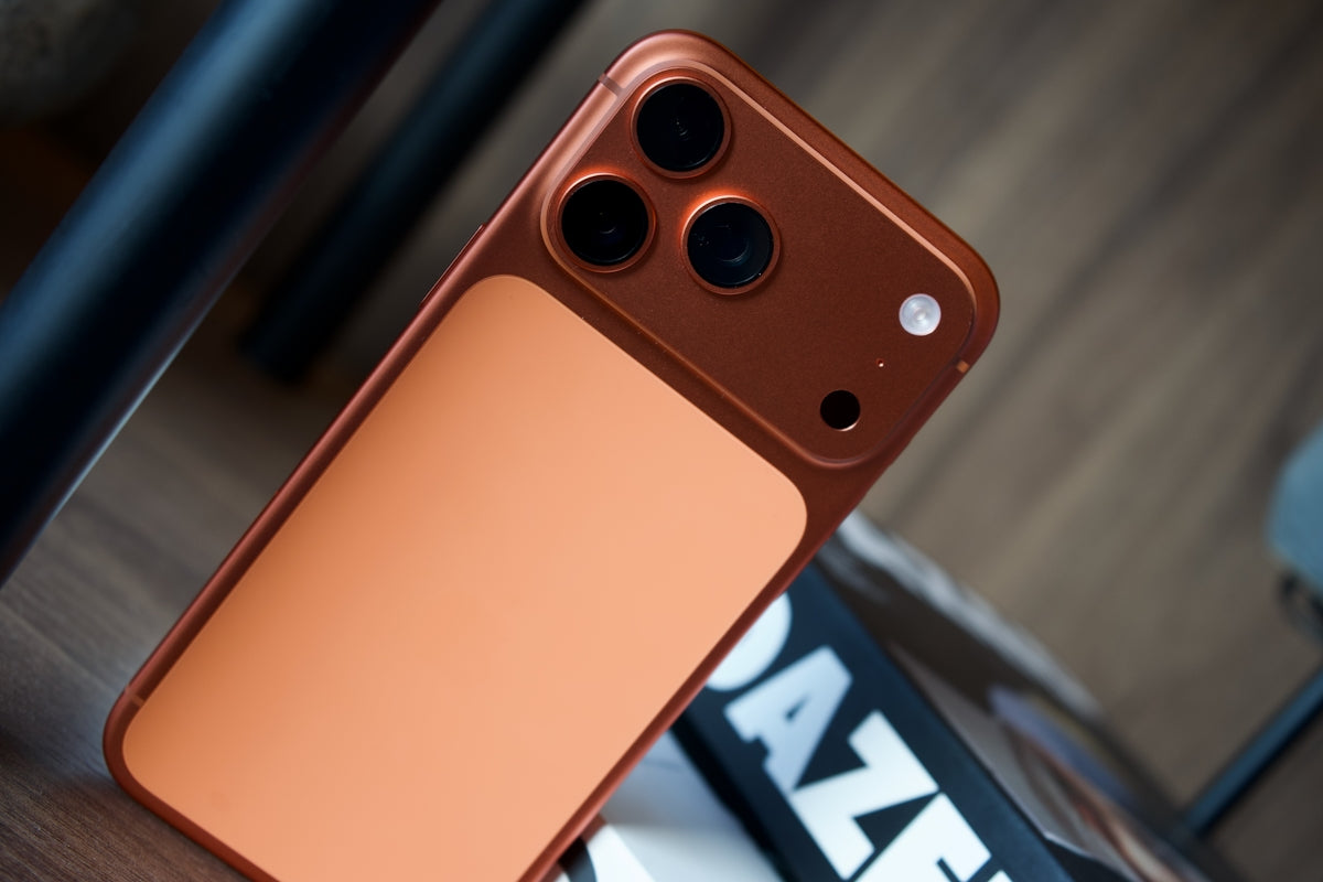 Close-up of a copper-colored smartphone with three cameras.